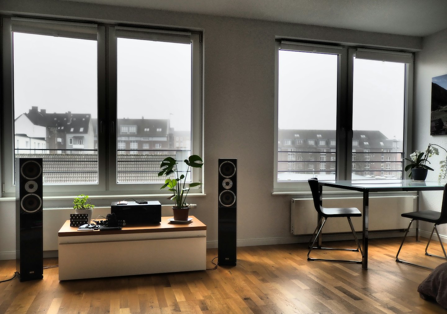 Modern living room with audio system and urban view.